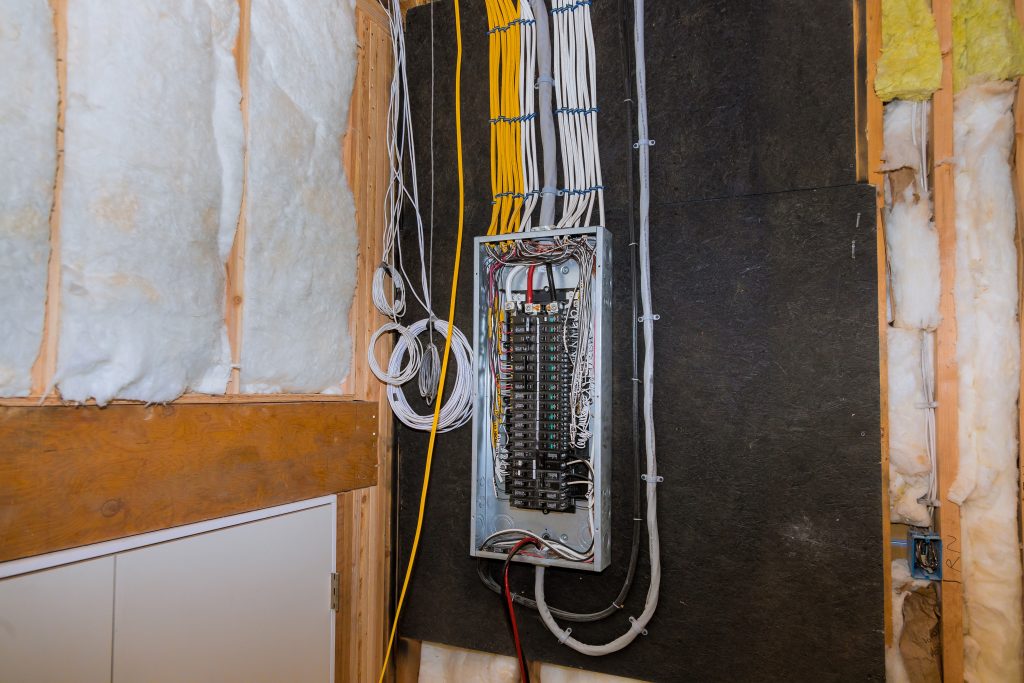 Wiring panel with multiple electrical terminals, surrounded by insulation material, illustrating modern electrical upgrades relevant to knob and tube replacement in older homes.